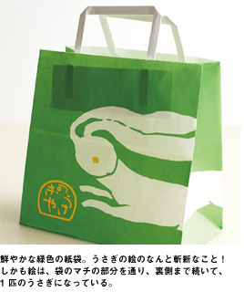 鮮やかな緑色の紙袋。うさぎの絵のなんと斬新なこと!しかも絵は、袋のマチの部分を通り、裏側まで続いて、1 匹のうさぎになっている。